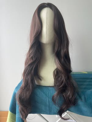 Real product photo of long wavy synthetic wig front view in natural light