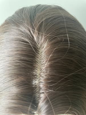 Real product close-up of synthetic wig middle part in natural light
